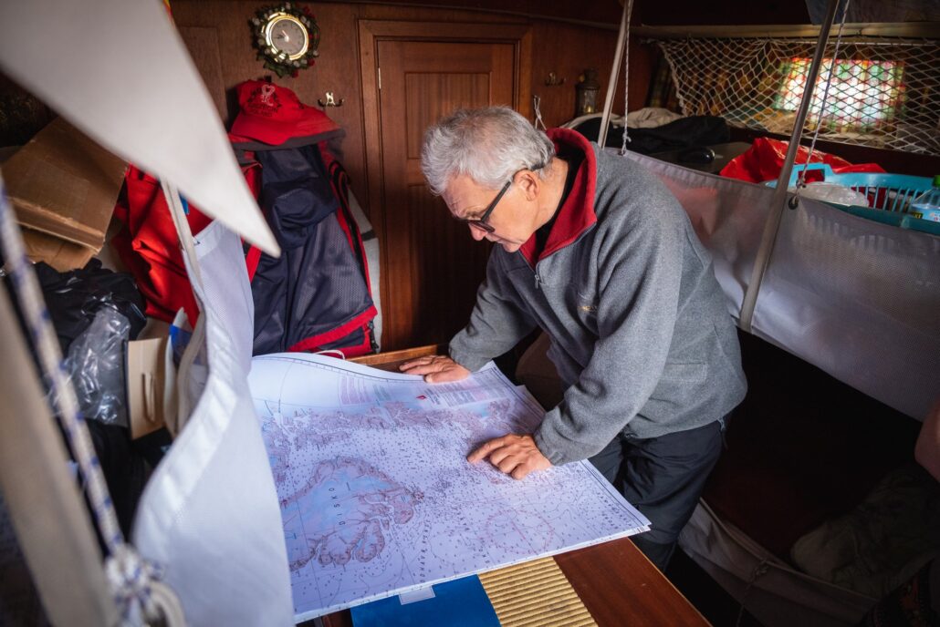 Grzegorz Węgrzyn pokazujący na mapie trasę swojej żeglugi